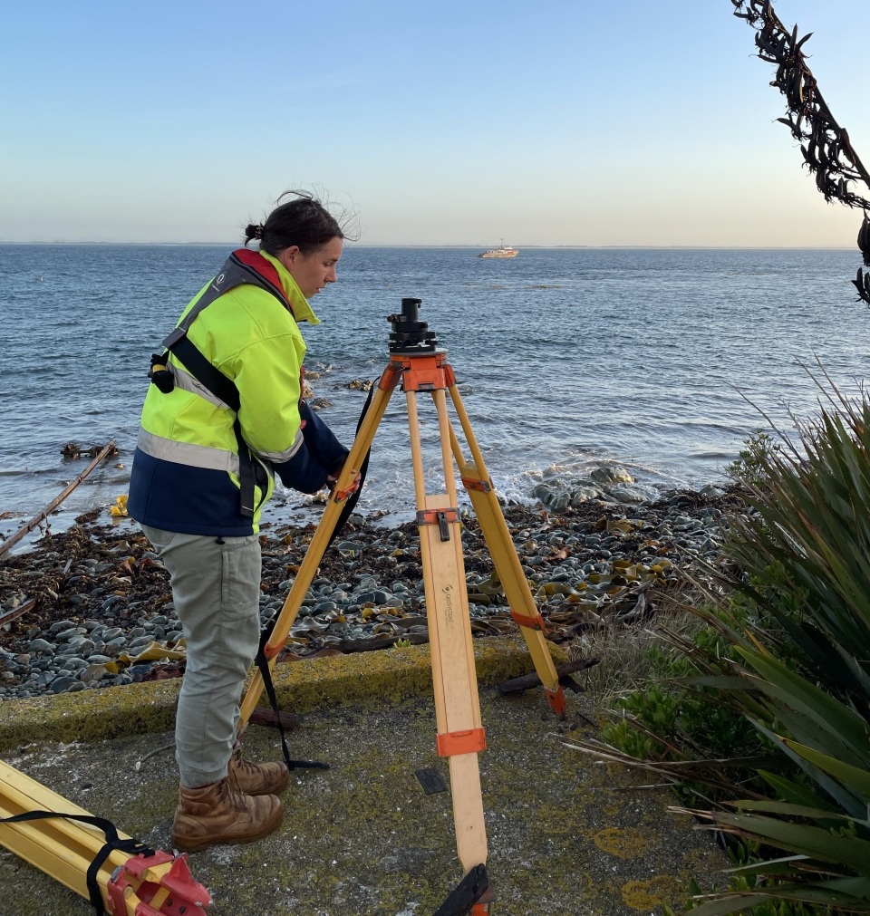 Kate sets up geodetic equipment for tide gauge installation at Dog Island, Foveaux Strait. Image: DML.